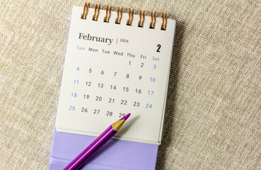 Desk calendar for February 2024 and on the table with copy space.