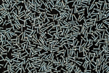 Metal self-tapping screws on black background