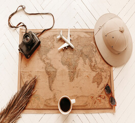 Top view of vintage world map with objects related to journey, excursions and tours