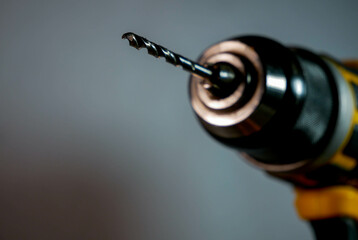 Electric drill, screwdriver with a dull metal drill bit close up shot, space for text. - obrazy, fototapety, plakaty