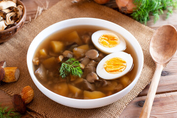 Traditional ethnic egg drop soup with egg on rustic wooden table
