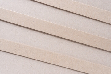 three cardboard stripes on plain brown paper surface