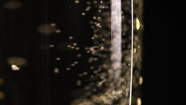 Glass of champagne on a black isolated background. Capturing the effervescence: Slow-motion, super macro shot showcasing delicate champagne bubbles gracefully rising in an elegant glass against a pris