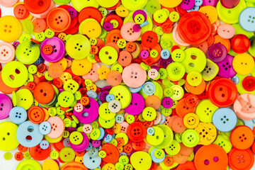 Scattered colorful buttons background. Pile of multicolored buttons. Sewing or tailoring work. Home needlework. Flat lay banner with buttons