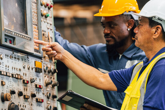 Industrial worker indoors in old factory. Industrial man Engineers in Hard Hats.Work at the Heavy Industry Manufacturing Factory.