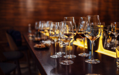 Glass goblets placed in rows on table during wine tasting procedure in restaurant