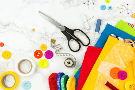 Sewing accessories with bright colors, top view. Colorful fabrics, buttons, strips and other materials for needlework. Tailor's equipments. Sewing and home needlework. Recycling of clothes