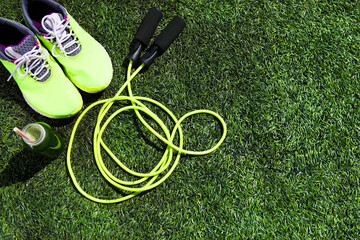 Running shoes, jump rope and drink bottle with green juice