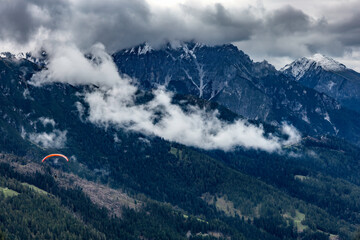 Paragliding in the Stubai Alps under cloudy skies