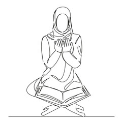 Muslim girl prays in front of the Koran
