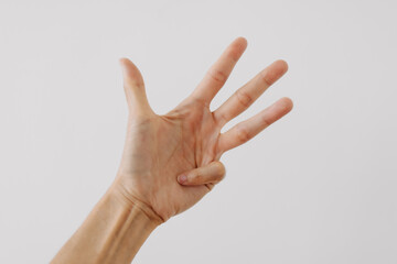 Photo of woman's hand showing numbers fours, counting fingers gesture, isolated on white background wall.