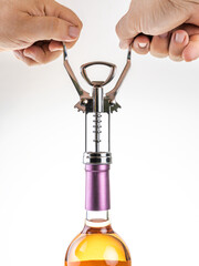 A man's hands opening a wine bottle on white background