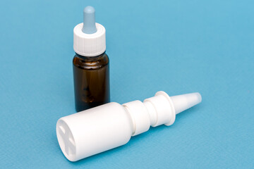 Medicine bottle with nasal drops on blue background