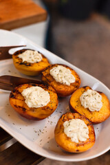 Grilled tasty cut peaches, served with whipped cheese cream, closeu