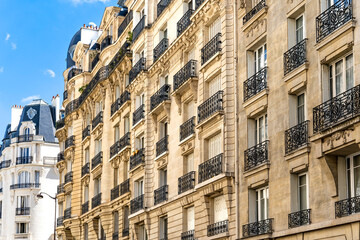 Glimpse of a typical and elegant residential building in Paris city center, France, with wrought iron railings and balconies 