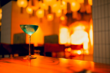 One delicious ice cold cocktail in exquisite glasses stand on a wooden table in a restaurant