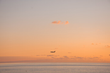 The plane is landing. Sunset on the sea coast.