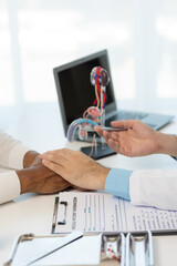 Close-up during consultation of a male patient suspected of having bacterial prostatitis. Prostate disease and treatment Anatomical model of the male reproductive system in the hands of a doctor.