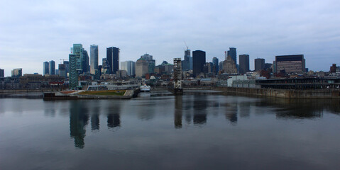 Fototapeta na wymiar Cityscape of Montreal, Qc reflecting in the St Lawrence River