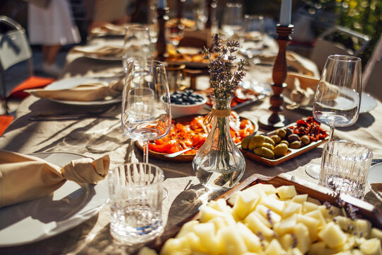 hairs and a table for guests, decorated with candles, are served with cutlery and crockery