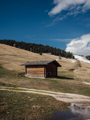 an old log cabin is sitting next to the snow capped mountain