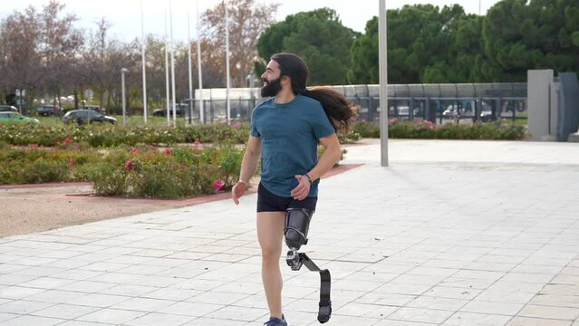 Physically disabled man with prosthetic leg running in an urban park