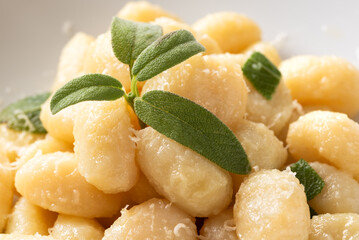 Piatto di deliziosi gnocchi di patate conditi con burro e salvia, tipica ricetta di pasta italiana,...