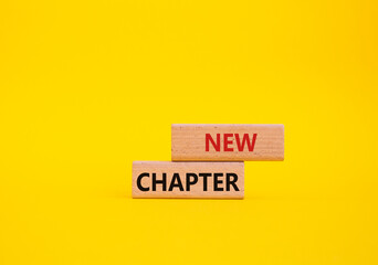 New Chapter symbol. Concept word New Chapter on wooden blocks. Beautiful yellow background....