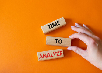 Time to Analyze symbol. Concept word Time to Analyze on wooden blocks. Businessman hand. Beautiful orange background. Business and Time to Analyze concept. Copy space