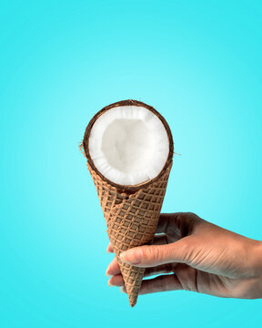 Coconut with ice cream cone on bright background. Food minimal concept.