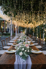long table decoration outdoors with a tent and drop lights and set up chairs