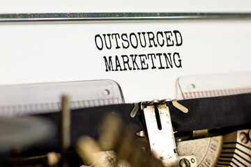 Outsourced marketing symbol. Concept words Outsourced marketing typed on beautiful old retro typewriter. Beautiful white paper background. Business Outsourced marketing concept. Copy space.