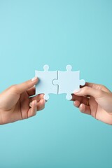Two hands holding puzzle pieces to complete the puzzle,