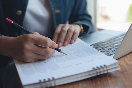 2024 Event planner timetable agenda plan on schedule event. Business woman checking planner, taking note on calendar desk on office table. Calendar event plan, work planning
