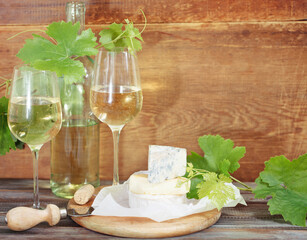 Glasses of white wine, bottle and cheese