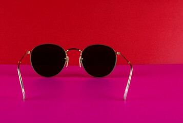 Metal Framed Sunglasses on a Pink Base and Red Background - 703979902