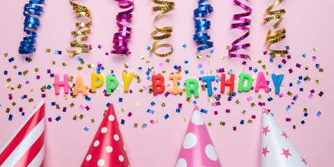 Colorful celebration background with various party confetti and candle decoration. Minimal birthday concept. Flat lay.
