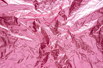 Abstract pink crumpled foil background. Minimal party concept.