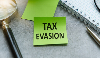 Tax Evasion Text on The Diary Paper for Writing on Gray Background.