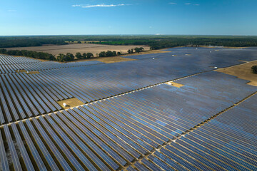 Aerial view of large sustainable electrical power plant with rows of solar photovoltaic panels for...