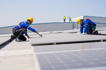 Specialist technician professional engineer checking top view of installing solar roof panel on the factory rooftop under sunlight. Engineers having service job of electrical renewable eco energy