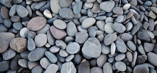 Foto auf Glas Smooth round pebbles texture background. Pebble sea beach close-up, dark wet pebble and gray dry pebble. High quality photo © Aleksandr Matveev