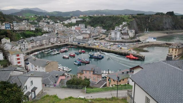 Above view to the moored boats in harbour of Luarca during cloudy winter day. Principal town in municipality of Valdes in Asturias, northern Spain. Travel destinations and touristic places concept
