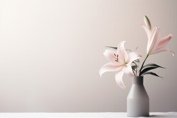  a vase filled with pink flowers sitting on top of a white table covered in a white table cloth next to a gray vase with pink flowers in front of a white wall.
