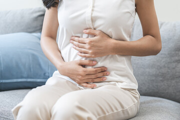 Flatulence ulcer, asian young woman, girl hands in belly, stomach pain from food poisoning,...