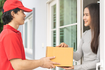 Delivery service asian young customer woman hand received cardboard box parcel from messenger male....