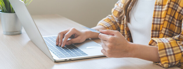 Internet banking, Online shopping at home, asian young woman hand in typing on keyboard, holding credit card, using laptop computer, spending money with purchase on store at home. Shopaholic ecommerce