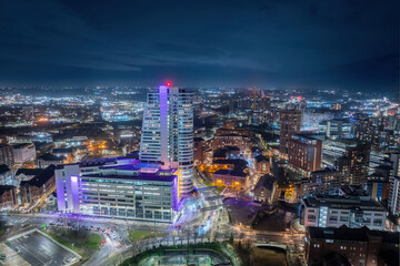 Obraz premium Leeds city centre at Night. Yorkshire city of Leeds after dark with city centre lights of offices, apartments and retail. Aerial view from near the train station