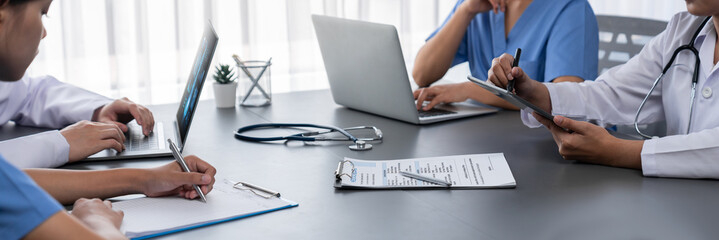 Doctor and nurse in medical meeting discussing strategic medical treatment plan together with report and laptop. Medical school workshop training concept in panoramic banner. Neoteric - obrazy, fototapety, plakaty