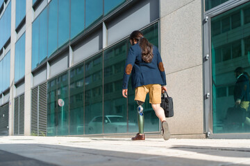 Naklejka premium Businessman with amputee leg walking along a financial district street